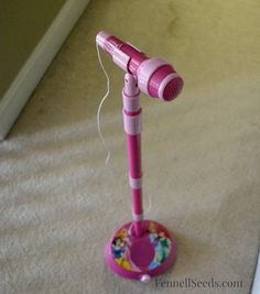 a pink hair dryer sitting on top of a floor