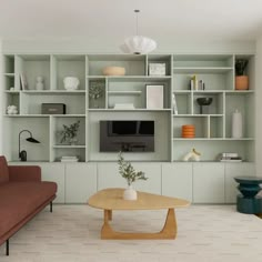 a living room filled with furniture and a flat screen tv sitting on top of a wooden table