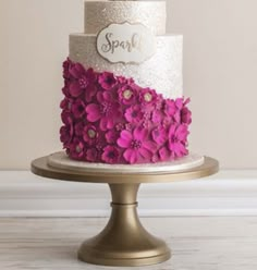 a three tiered cake with pink flowers on top