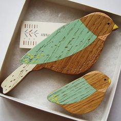 two wooden birds sitting on top of a box