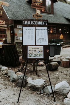 a sign that is sitting in the dirt near some rocks and gravel with signs on it