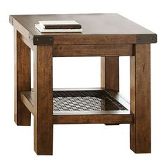 a wooden table with a book on top and a magazine rack under the side shelf