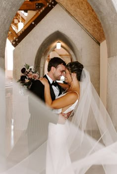 a bride and groom kissing in an archway