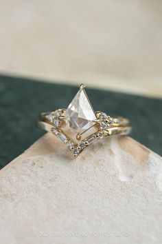 a white diamond ring sitting on top of a rock