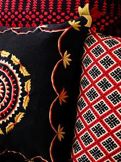 two black and red pillows sitting next to each other