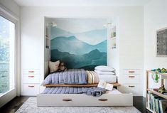 a bedroom with a bed, bookcases and wall mural