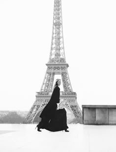 a woman standing in front of the eiffel tower