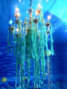 a chandelier hanging from the ceiling in an aquarium