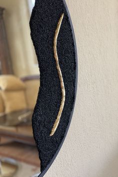 a mirror that is hanging on the side of a wall next to a couch and chair