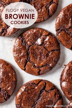 several chocolate cookies are on a white surface