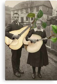 a man and woman standing next to each other holding an old fashioned luthi guitar