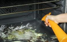 someone is cleaning the inside of an oven with a yellow hand held sprayer on it