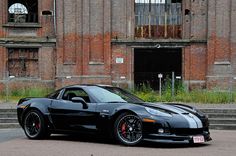 a black sports car parked in front of an old building