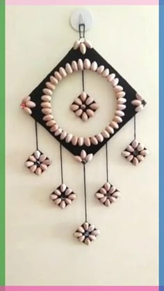 a black and white wall hanging with beads on it's sides, in the shape of a diamond