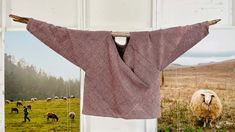 a sweater hanging on a clothes line in front of a sheep photo and an open door