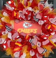 a wreath with the word chiefs on it is hanging on a front door in red, yellow and white mesh