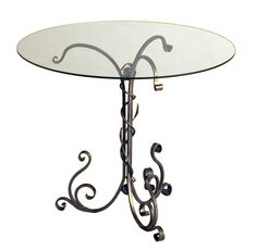 a glass and metal table with swirly designs on the top, against a white background