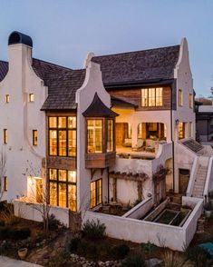 a large white house with lots of windows on the front and side of it at night