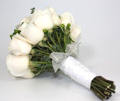 a bridal bouquet with white roses and ribbon tied around the end, on a plain surface