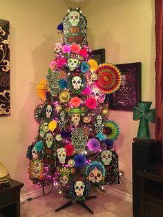 a brightly colored christmas tree decorated with sugar skulls