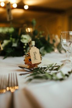 the table is set with silverware and greenery