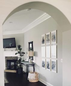 a living room with pictures on the wall and a fireplace in the corner next to it