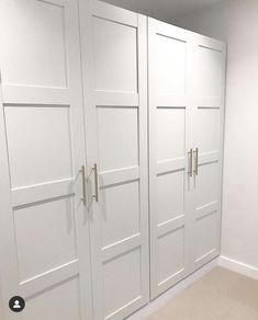 an empty room with white closet doors and beige carpet