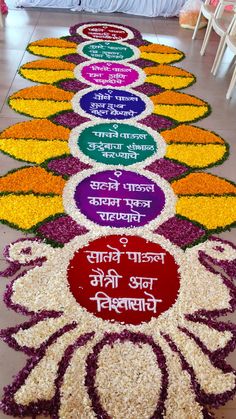 a long row of flowers with words written in different languages on the petals and surrounded by chairs