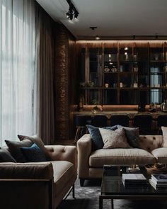 a living room with two couches and a coffee table in front of a window