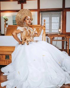 a woman in a wedding dress holding a dog