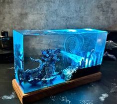 an aquarium with two godzillas in it sitting on a table next to a lighter