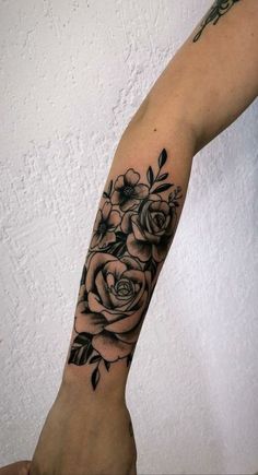 a black and white rose tattoo on the arm