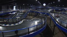 there are many ramps in the middle of an indoor race track that is lit up at night