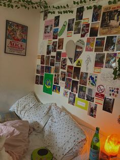 there is a bed with many pictures on the wall and a lamp next to it