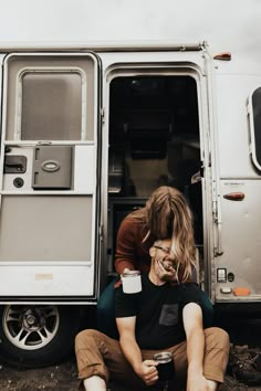 two people sitting on the ground in front of a food truck with their eyes closed