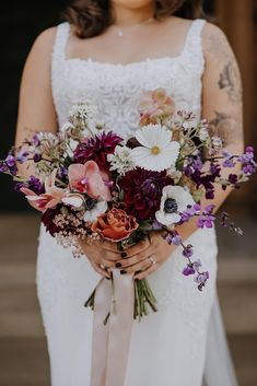 a woman holding a bouquet of flowers in her hands