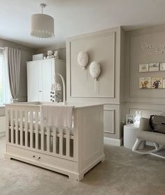 a baby's room with white furniture and decor