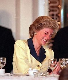 a woman sitting at a table with wine glasses