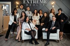 a group of people posing for a photo in front of a sign that says extreme realty