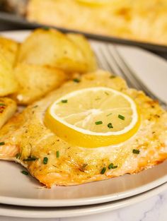 a white plate topped with fish and potatoes