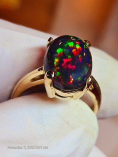 Very bright black opal 10x14mm 5.24cts. nice consistent  galaxy pattern mounted on a simple solitaire solid 14k gold ring, I like the simplicity and solidness of this ring,its heavy for it's size.  Hard to photograph the stone because it is so bright, looks even better in person. I will tighten the prongs when the ring size is determined. Black Opal Jewelry, Black Fire Opal, Galaxy Pattern, Black Opal Ring, Rainbow Opal, Ring Opal, Opal Ring Gold, Black Fire, Three Rings