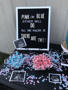 a table topped with pictures and confetti next to a sign that says pink or blue either will do