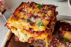 lasagna casserole being lifted with a fork from a dish on a table