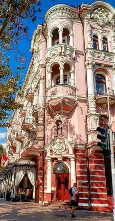 a tall pink building sitting on the corner of a street