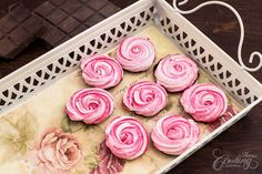 pink cupcakes are sitting in a white tray