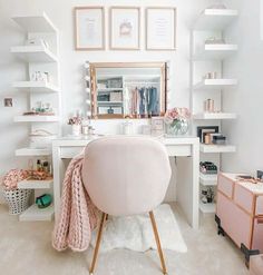 a white desk with a mirror and pink chair in front of shelves filled with books