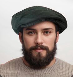 a man with a beard wearing a green beret on top of his head and looking at the camera