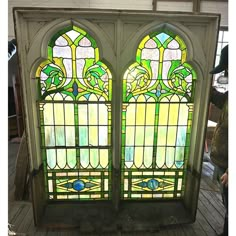 two stained glass windows sitting on top of a wooden floor