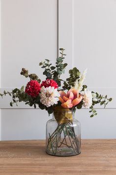 a vase filled with flowers sitting on top of a wooden table