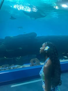 a woman standing in front of an aquarium